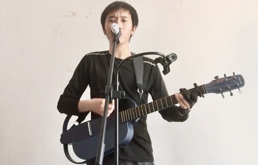 Blue guitar and person singing on a microphone while standing