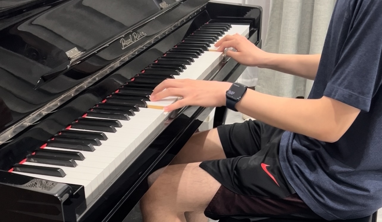 Black piano with person playing on a sideview